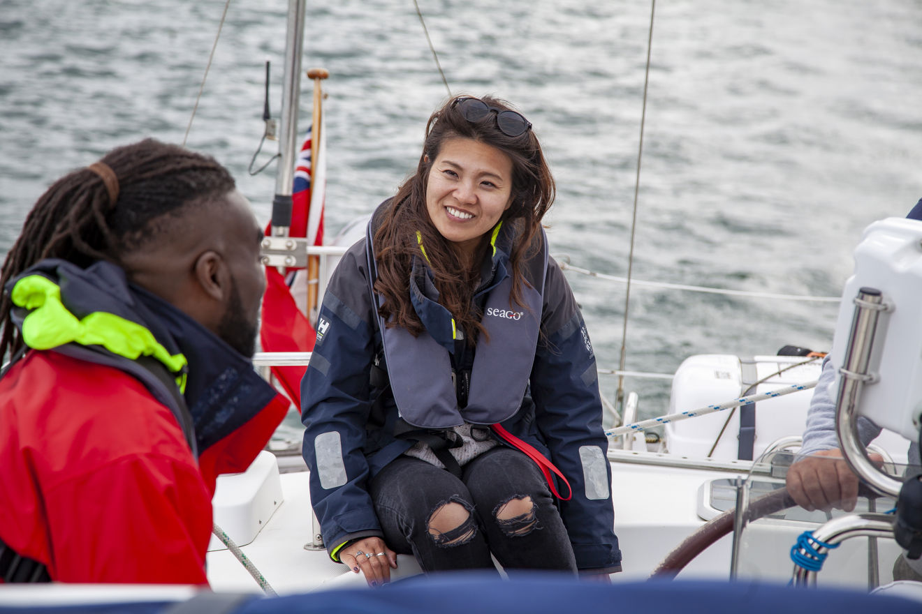 two people talking on a boat while wearing life jackets