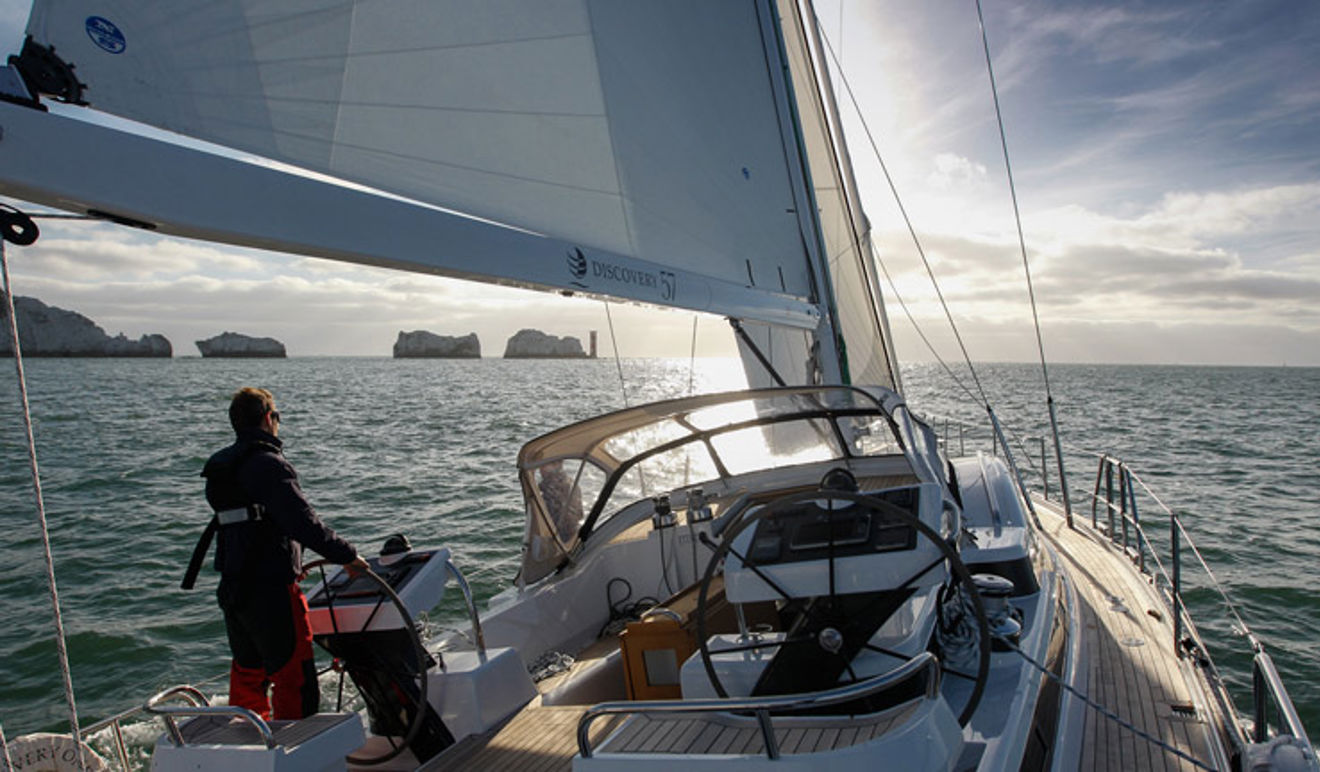 Woman sailing a yacht across calm waters 
