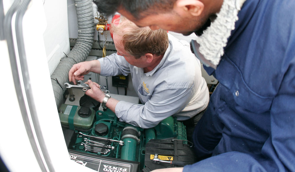 Two men fixing a boat engine 
