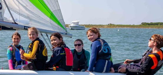 Mid shot of children smiling on boat