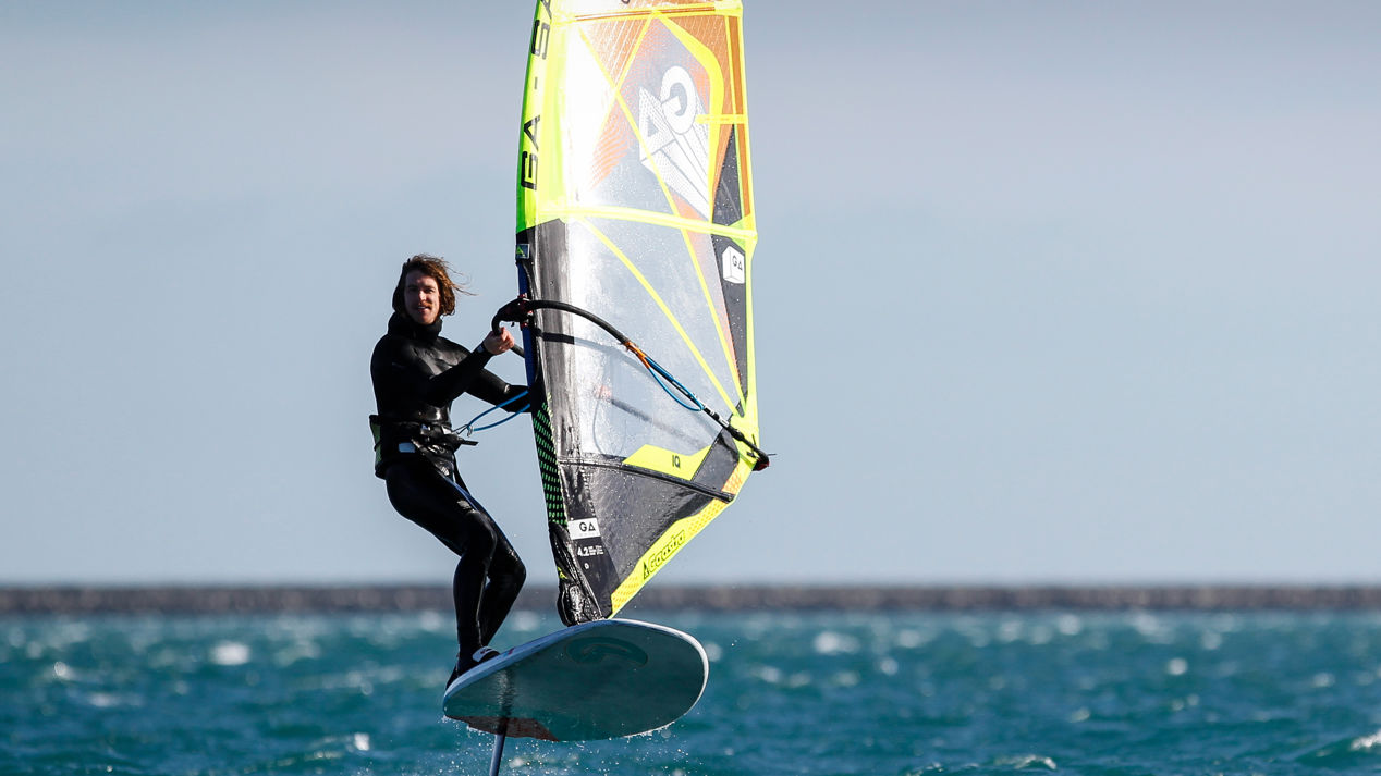 mid shot of solo windsurfer in low light