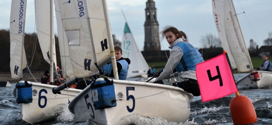 A team from Royal Hospital School sailing towards a mark in close competition with other boats at the RYA Women's Team Racing Championships 2025.