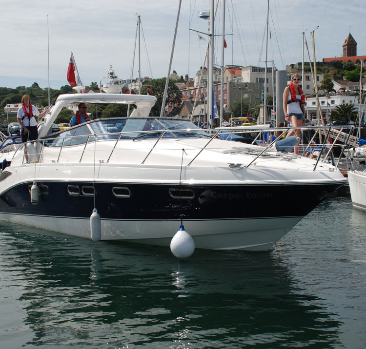 Motor cruiser moored at marina on sunny day
