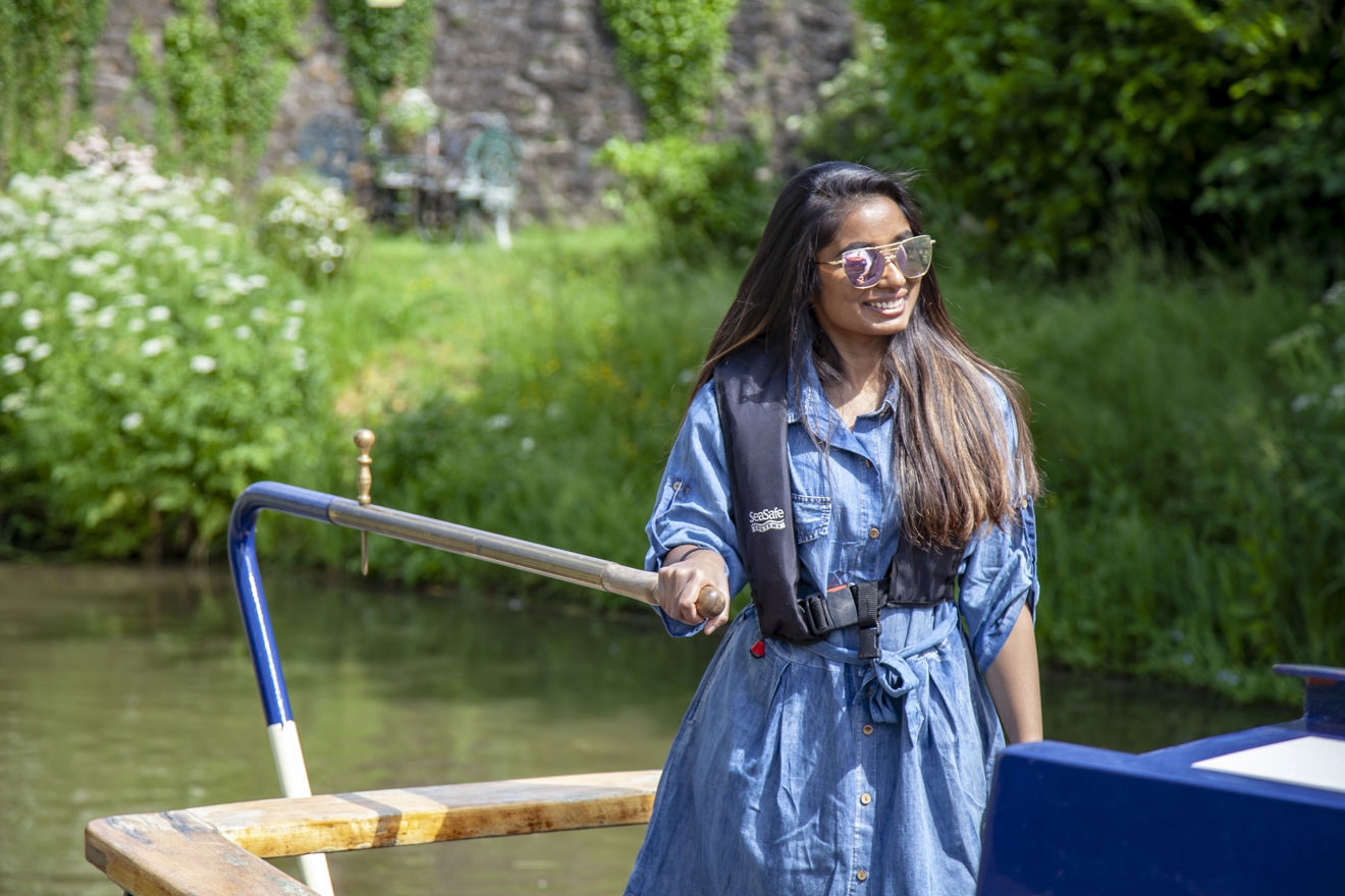 young woman operating a narrow boat 