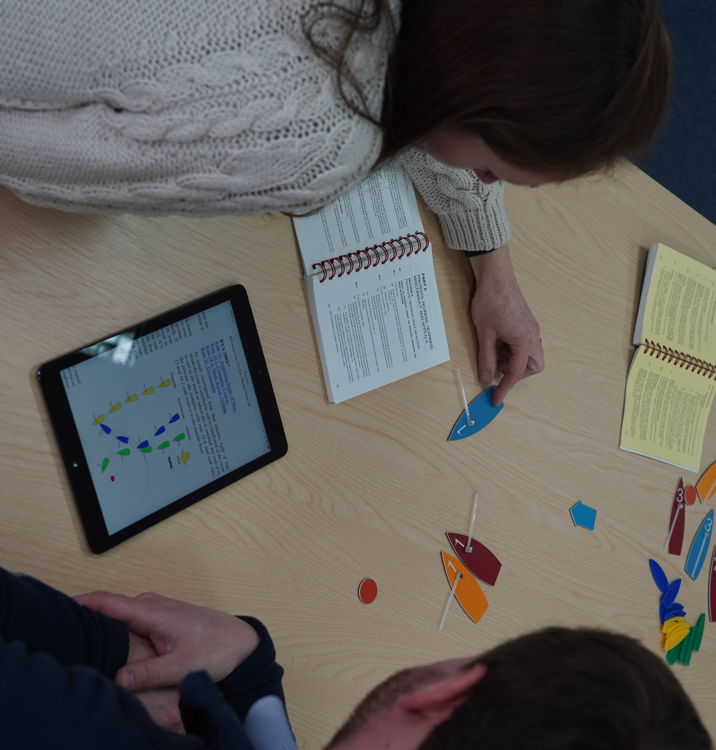 An image of a woman and man sitting and discussing about rules on their digital device
