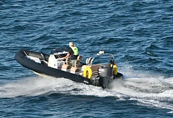 A rigid inflatable dinghy (RIB) being driven out on the open water from Yacht Sail Training School, Brac Island, Croatia