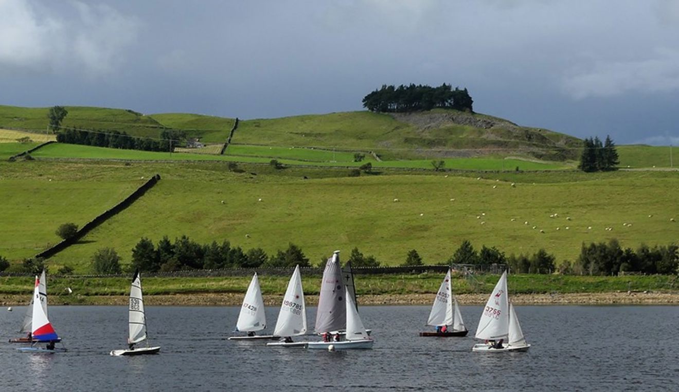Dinghies sailing at Teesdale with green hills in the background