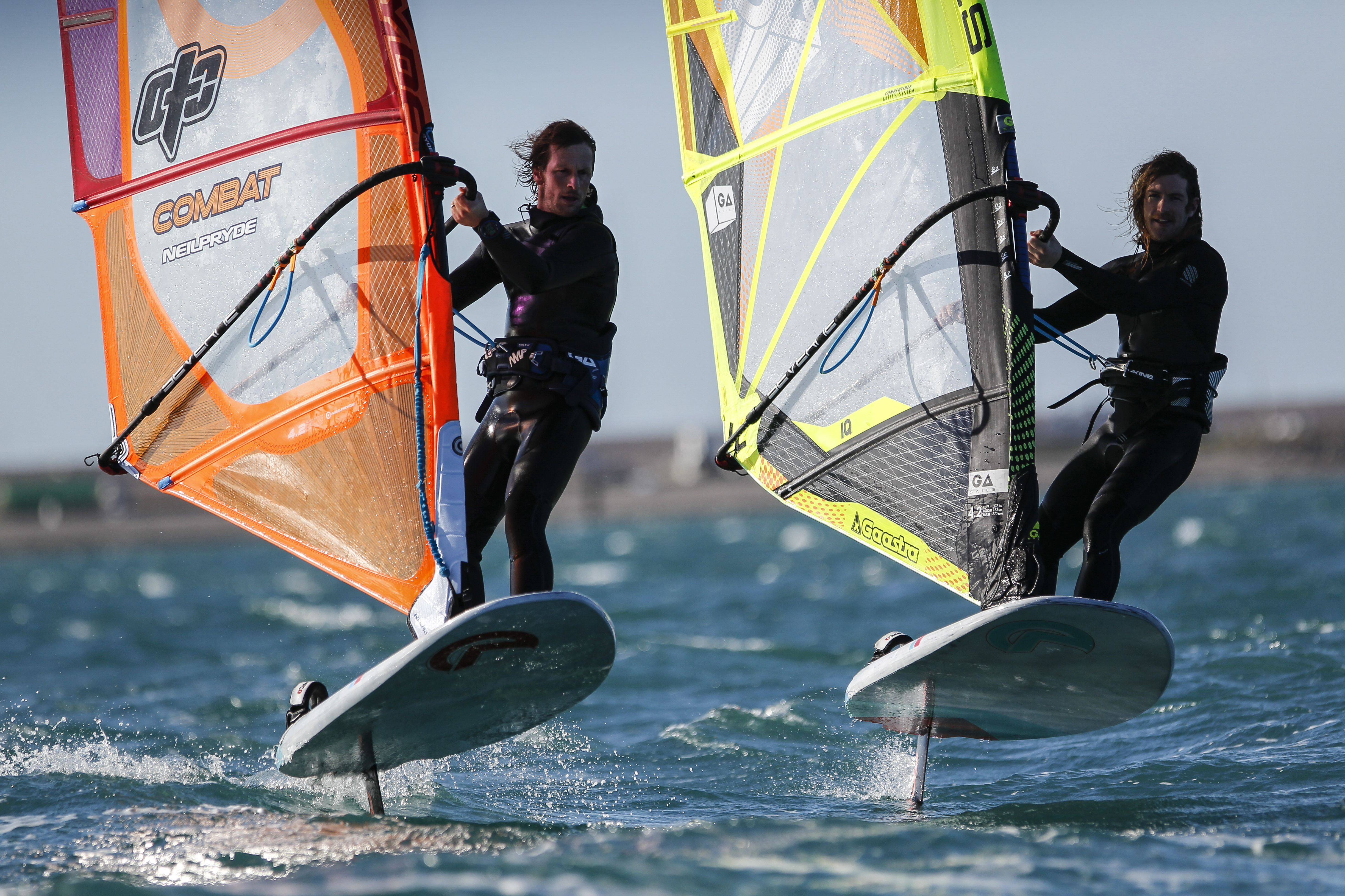 Windsurfers cutting through blue waters