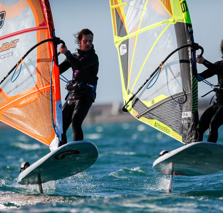 Windsurfers cutting through blue waters