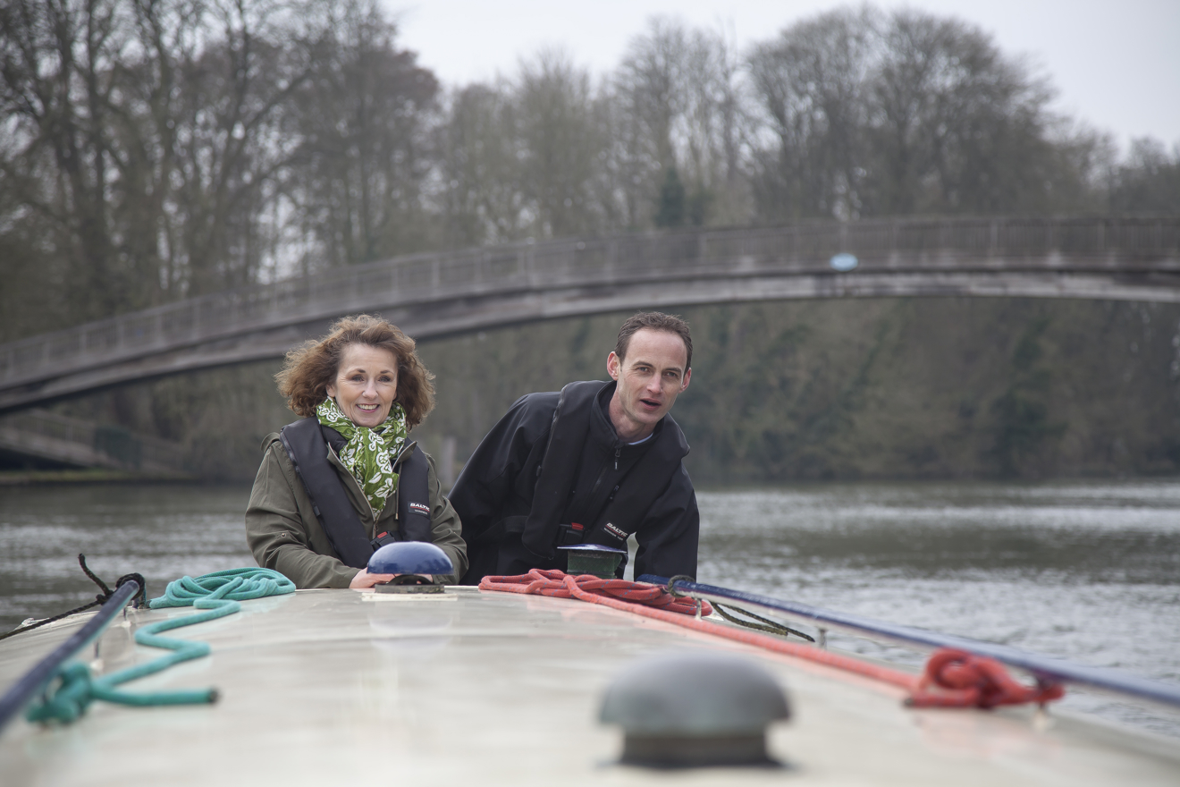 Man and a woman standing at the end of a canal boat