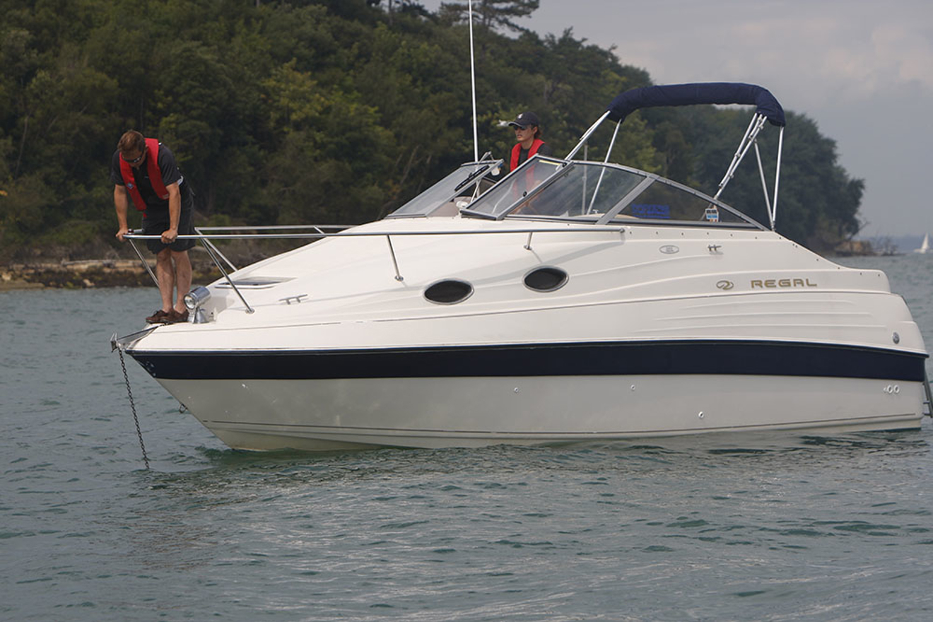 Man stood over bow trying to anchor with care