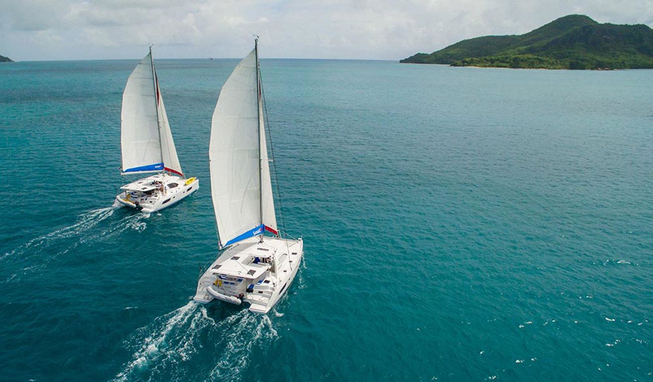 two yachts sailing side by side in the ocean