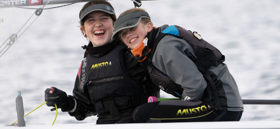 	An image of two young girls laughing while sailing the boat