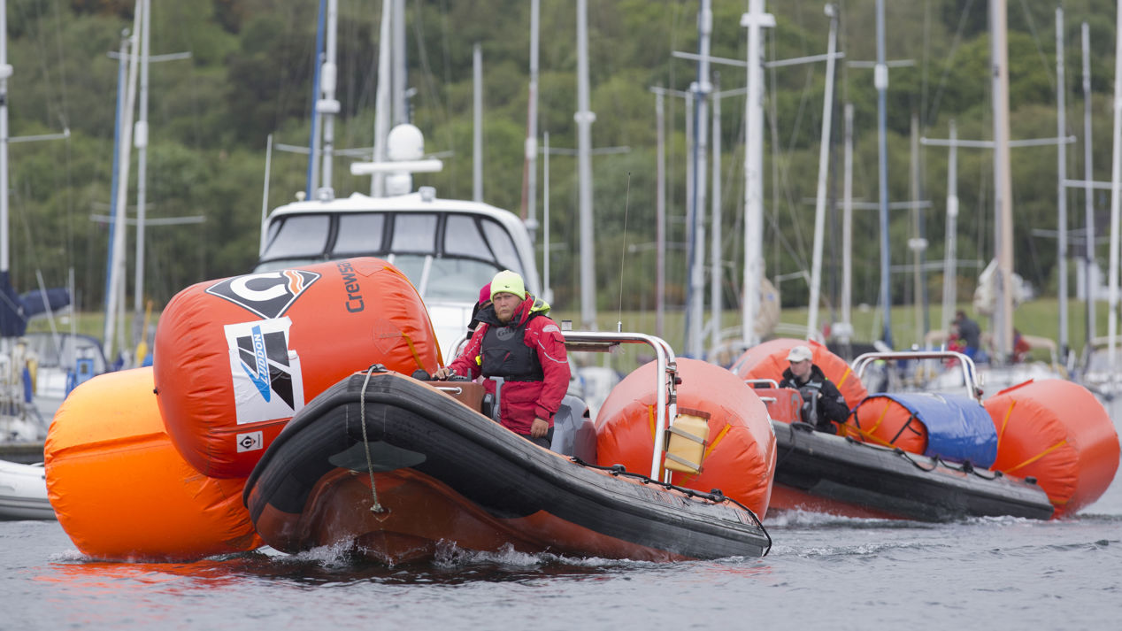 An image of a mark layer on a boat preparing for the race with all the equipment for the race