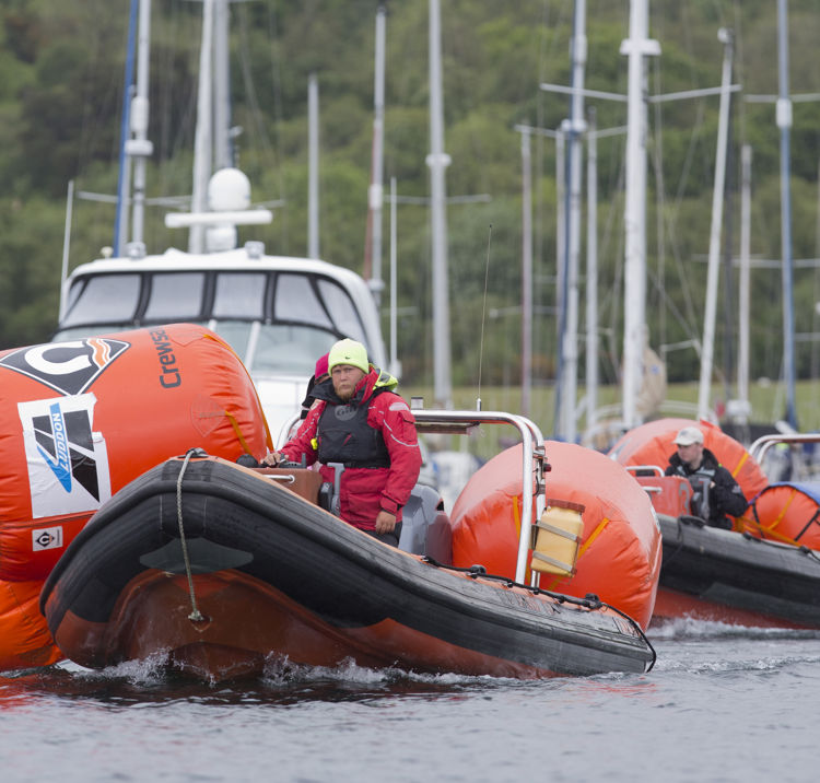 An image of a mark layer on a boat preparing for the race with all the equipment for the race