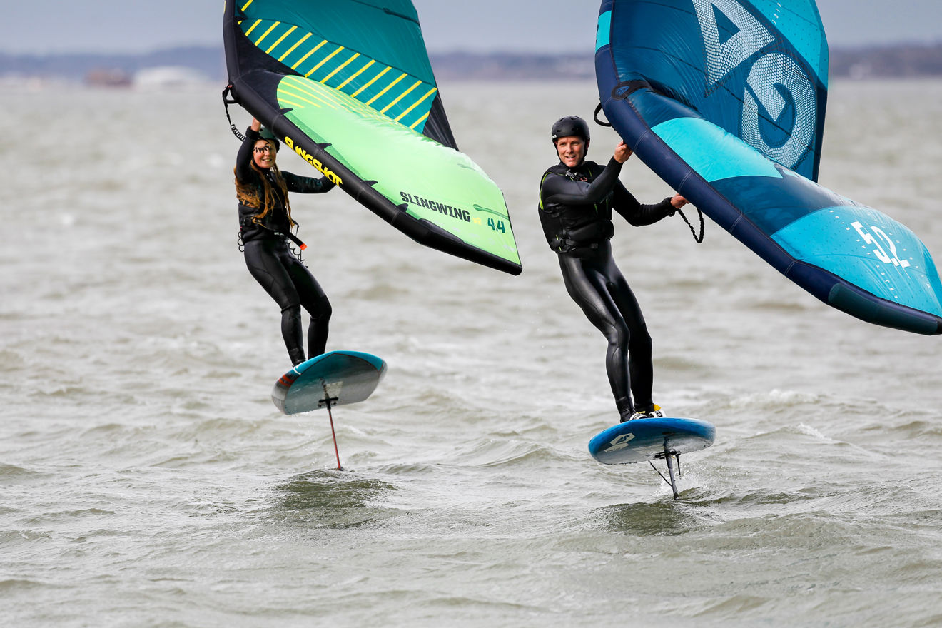 two people wing foiling on the open water