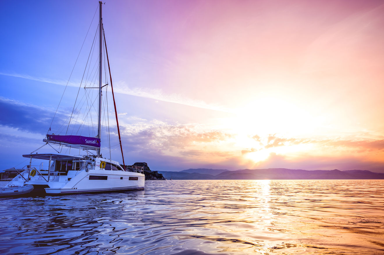 Sunsail catamaran in the ocean with a beautiful sunset