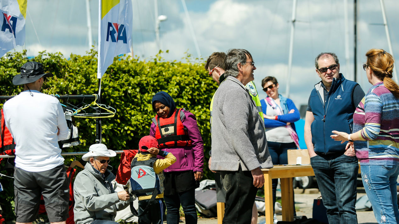 Busy scene of volunteers helping get people on the water