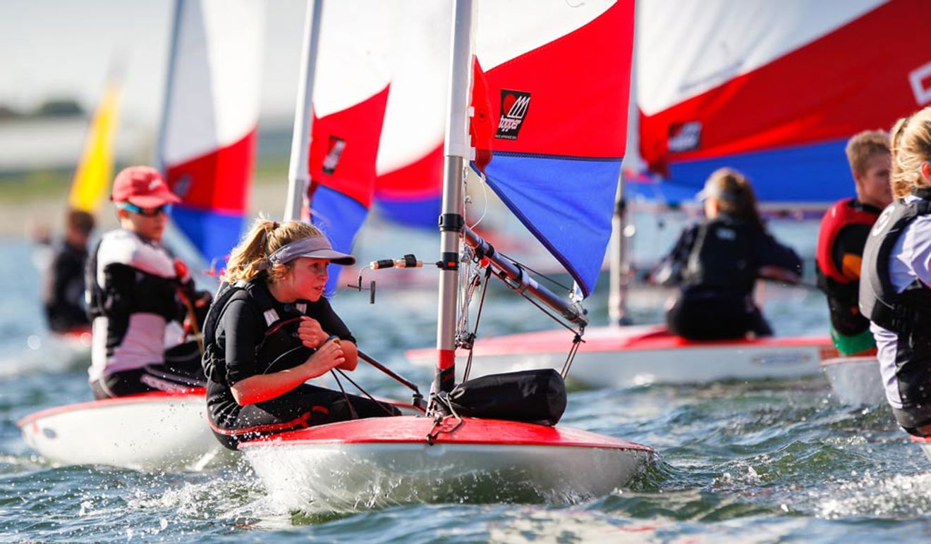 group of young children sailing dinghies