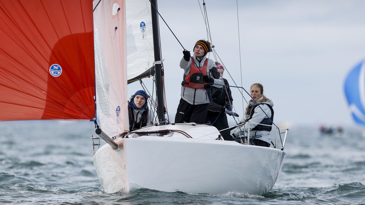 Sailors adjusting their boat's sail