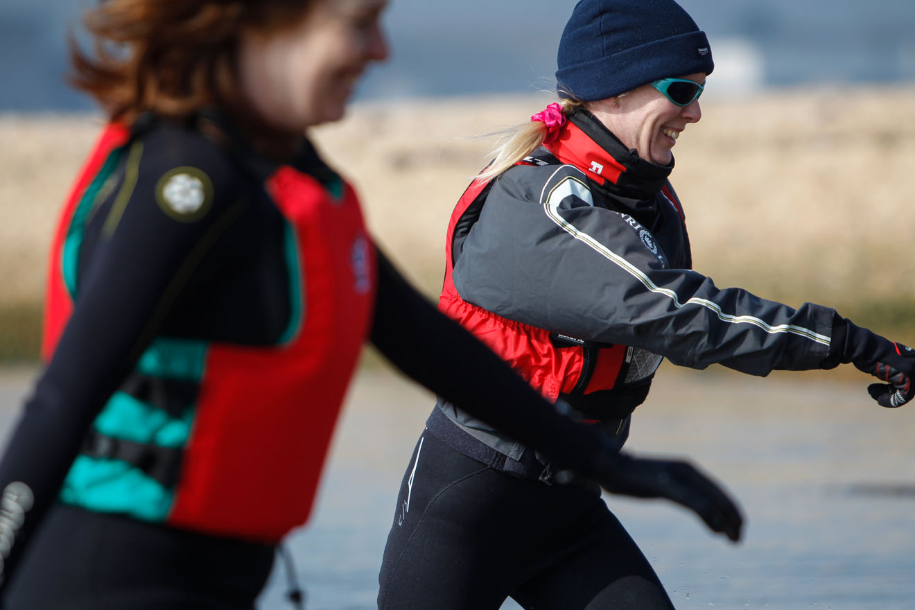 close up of two women running through shallow water