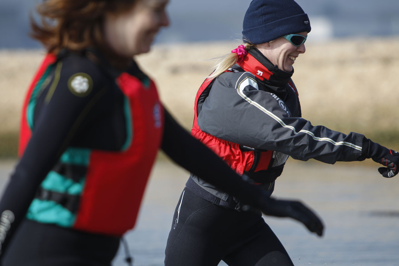 close up of two women running through shallow water