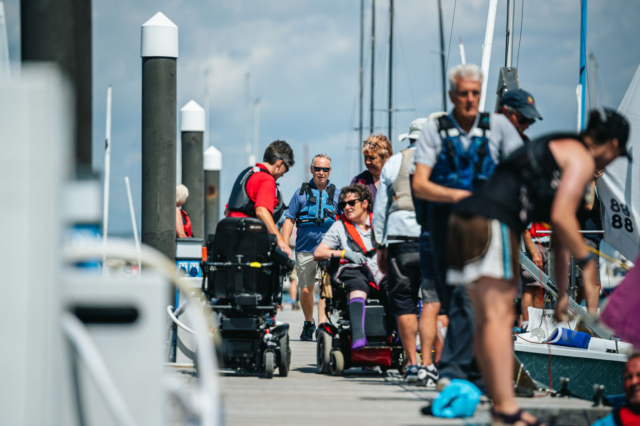 wheelchair using sailors on deck walking towards boats