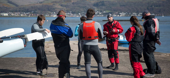Long shot of group of sailors being given an introduction to a sailing course