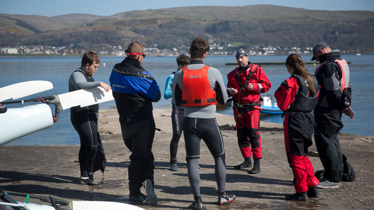 Long shot of group of sailors being given an introduction to a sailing course