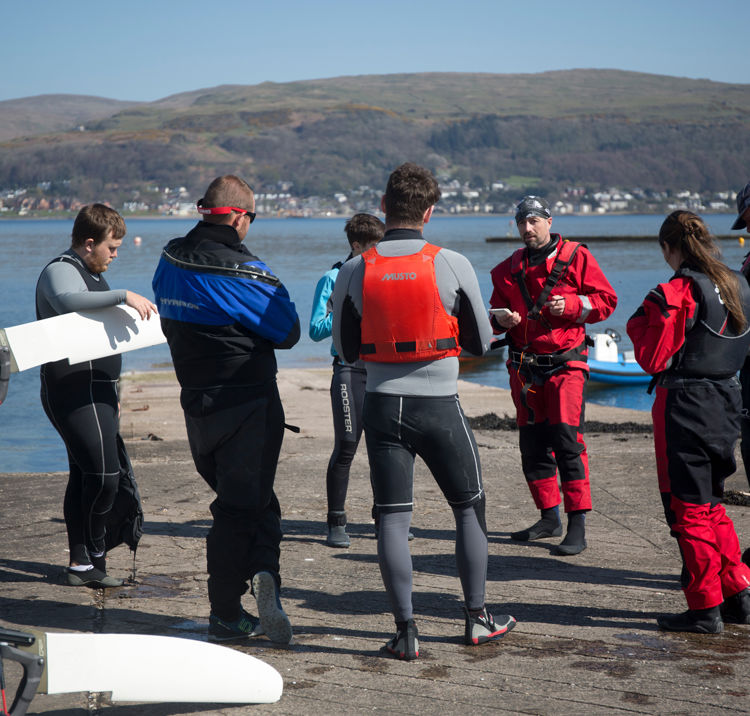 Long shot of group of sailors being given an introduction to a sailing course