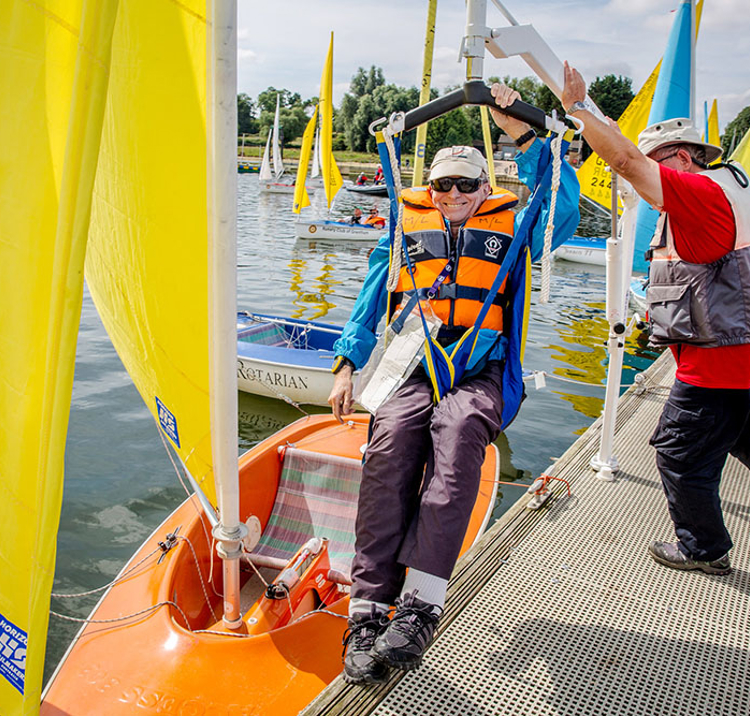 Sailability sailor being lowered into boat