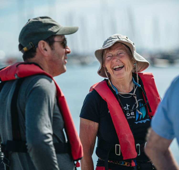 Volunteers smiling and laughing in front of the water