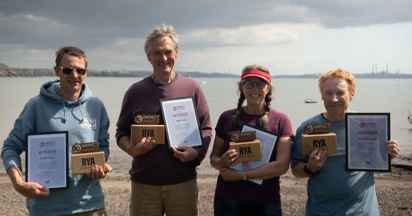 Volunteers (L-R) David Picker, Bob Jones, Leslie Burton and Graham Smith of the Windswept Warriors on the beach with their RYA Cymru Wales Impact Awards (c) Owen Canton