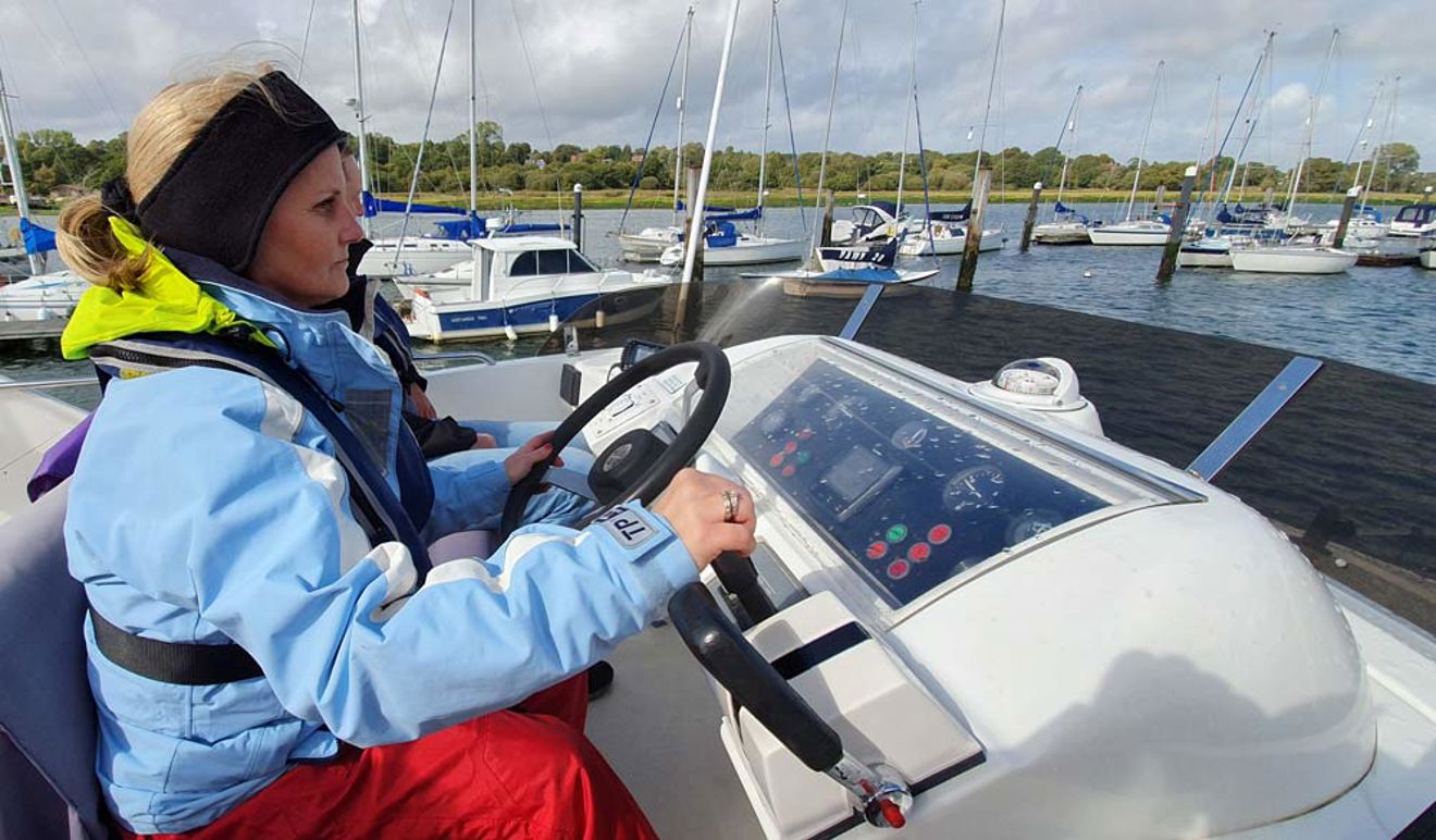 Close up of Justine Bowman driving a motor cruiser