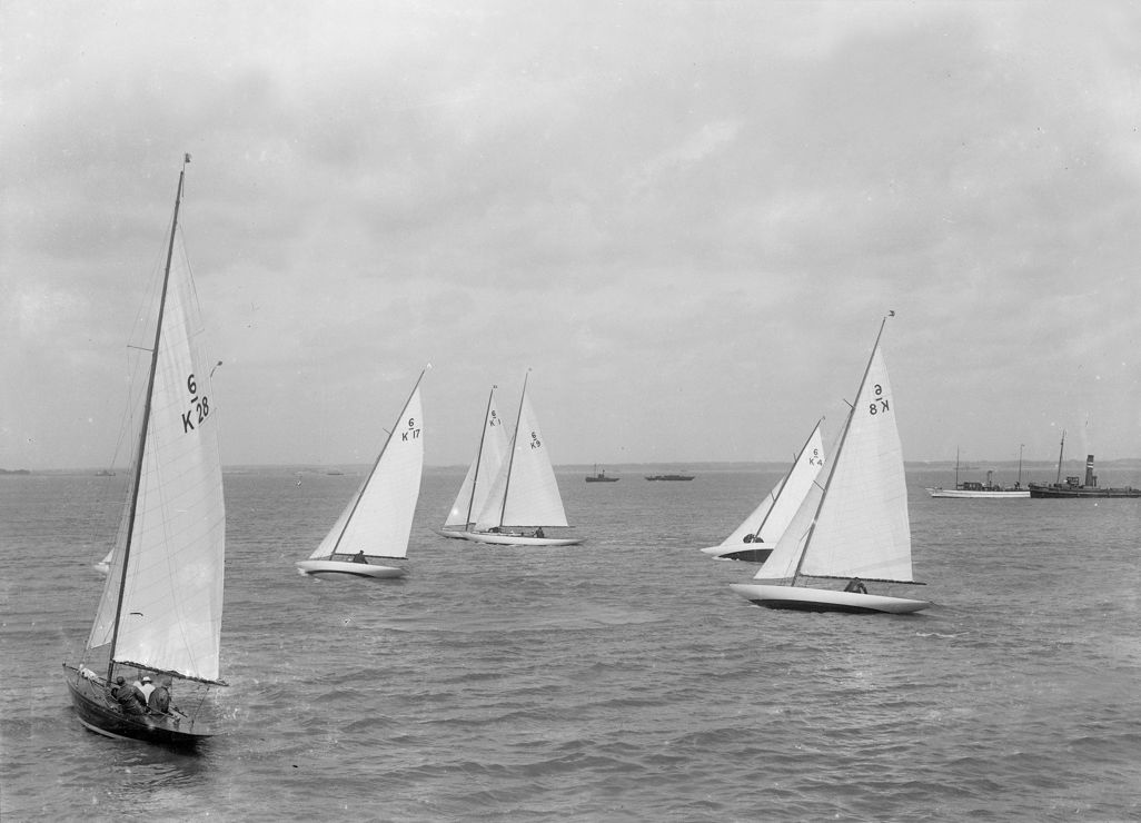 Black and white image of traditional wooden sailing boats travelling across the water