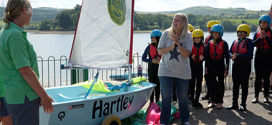 Retiring headteacher Sandra Hartley is surprised with an RYA Impact Award for incorporating sailing as part of her school's outdoor education programme