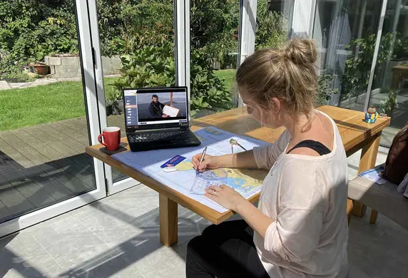 A lady studying charts at home for her RYA certificate with Ardent Training, Argyll, Isle of Mull