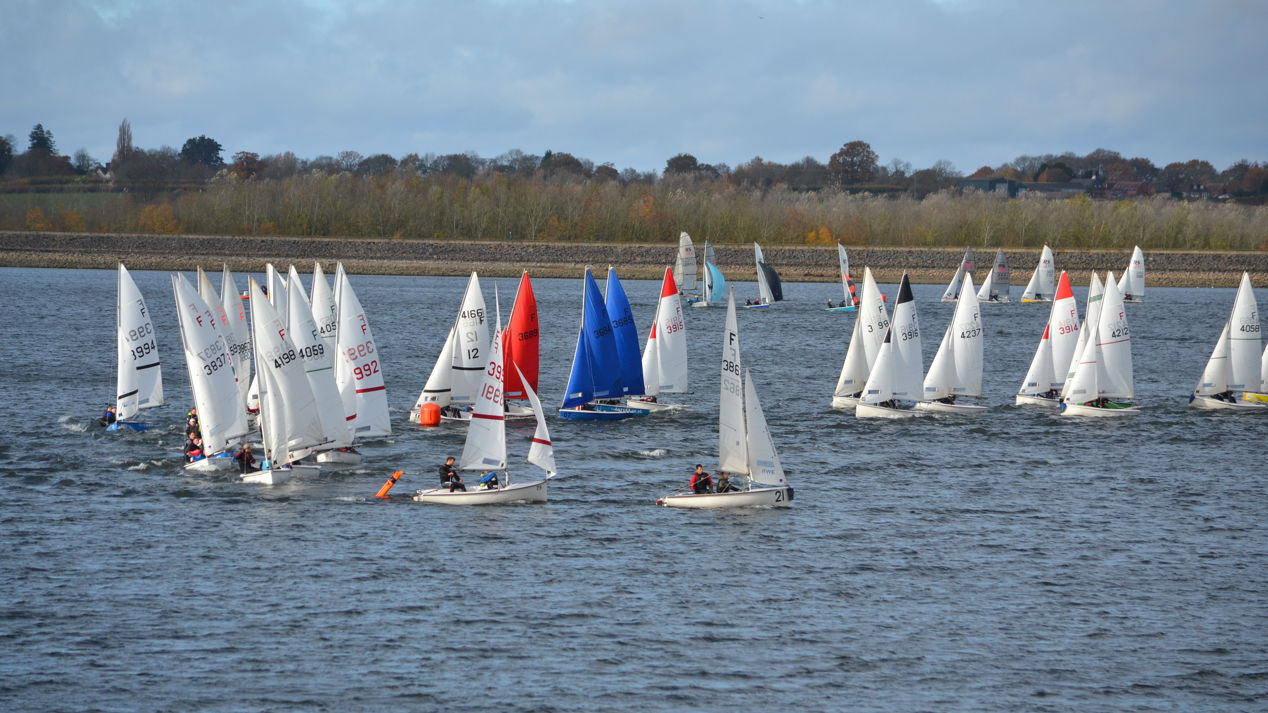 Very long shot of fleet of sailboats on water