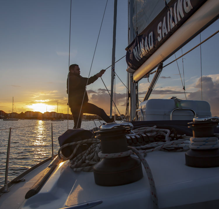Adjusting sails at sunset