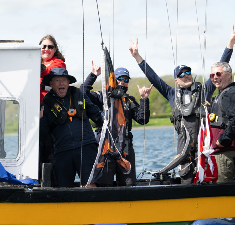 Race officials smiling on a boat