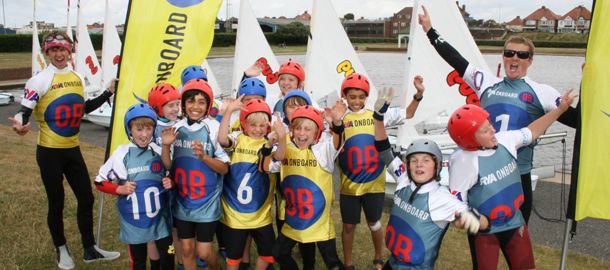 Children part of RYA onboard posing and smiling at the camera