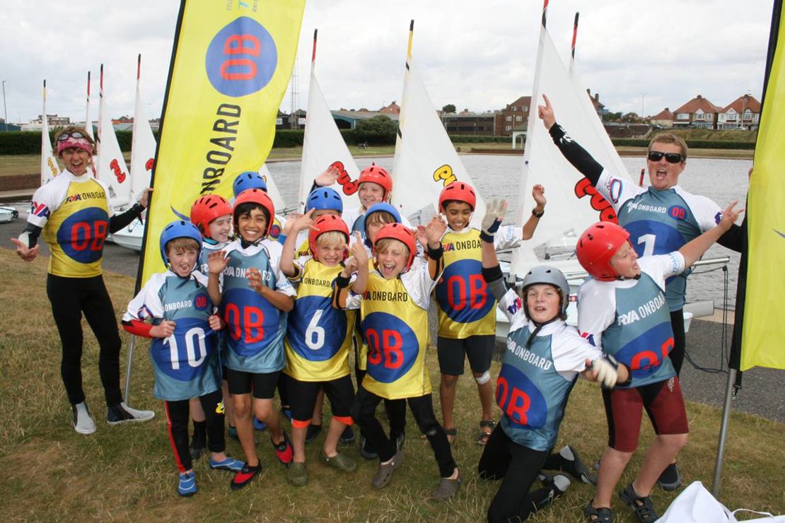Children part of RYA onboard posing and smiling at the camera