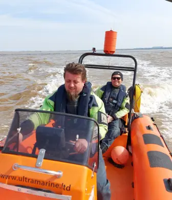 Two men speeding across the water in a Humber Rescue Service rigid inflatable boat (RIB)