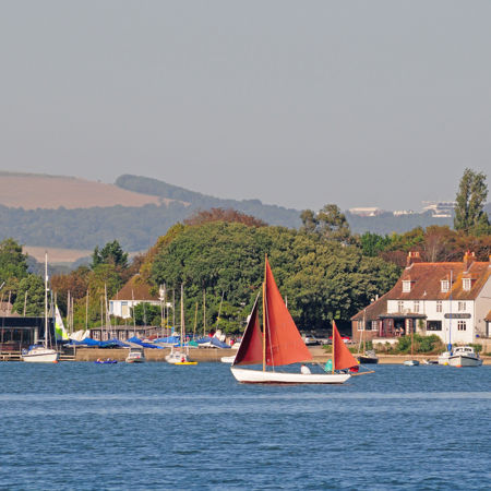 Sailboat in the water with rolling hills in the distance