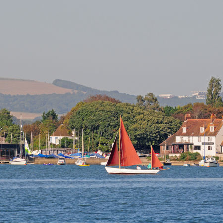 Sailboat in the water with rolling hills in the distance