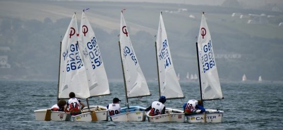 Five Optimists rafted up and sailors having a chat at the Welsh Regional Junior Championships 2025.