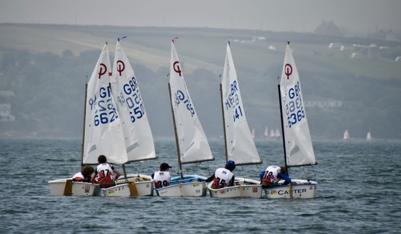 Five Optimists rafted up and sailors having a chat at the Welsh Regional Junior Championships 2025.