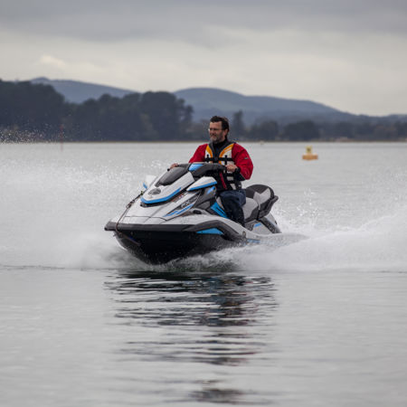 Man on a personal watercraft speeding through the ocean