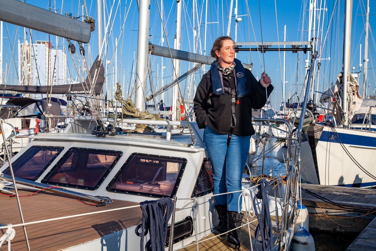 Long shot of Ella standing on boat looking out