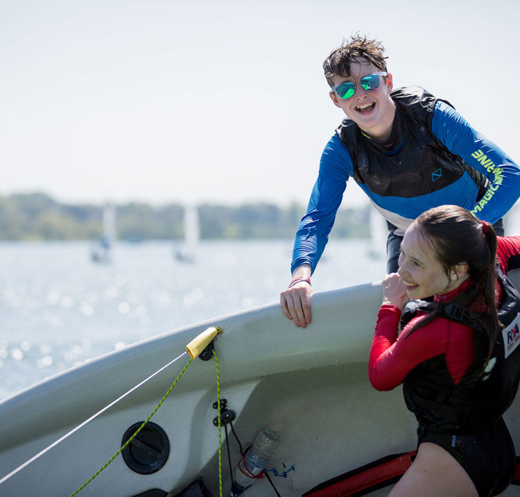 Two young people laughing over a capsized boat